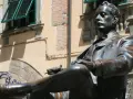 Statua di bronzo in piazza San Michele a Lucca, un uomo elegante con sigaretta.