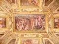 Soffitto affrescato con scene storiche e figure mitologiche, un capolavoro che evoca la grandezza del **Palazzo Vecchio**.