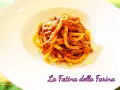 Pici alla nana, un piatto di pasta fatta in casa condita con un ricco ragù, servito su un piatto bianco.