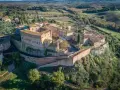 Borgo medievale di S. Giovanni d'Asso, con il suo imponente castello e le case in pietra, domina le dolci colline toscane.