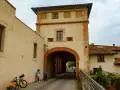 Un arco imponente a Santa Maria a Monte, con una coppia che osserva la strada. Una bici carica attende.