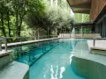 Piscina termale con cascata e alberi circostanti: un'oasi di relax da scoprire tra le cose da vedere a Chianciano Terme.