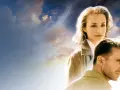 Volti di Kristin Scott Thomas e Ralph Fiennes sotto un cielo nuvoloso, evocano l'atmosfera de "Il Paziente Inglese".