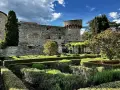 Giardini curati e torri antiche del castello di Meleto, un luogo ideale per visite indimenticabili.