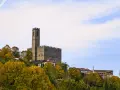 Castello medievale su una collina, circondato da alberi autunnali. Forse è qui dove hanno girato il ciclone.