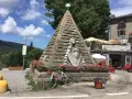 Le piramidi di Abetone, con una bici da corsa appoggiata, circondate da fiori e un ristorante.