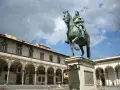 Statua equestre nella piazza della Santissima Annunziata, Firenze. Edifici storici con portici sullo sfondo.