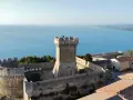 Rocca di Populonia, uno dei luoghi imperdibili da vedere a Piombino, domina il mare blu.