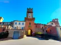 Torre dell'orologio a Marciano Italia, con un arco medievale e case in pietra.