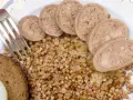 Piatto con grano saraceno, pane nero, cipolle e fette di collo ripieno.