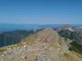 Panoramica mozzafiato dal monte Argegna, con il mare azzurro all'orizzonte e le cime rocciose che si stagliano contro il cielo limpido.