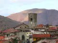 Torre medievale e tetti rossi a Careggine, un borgo incantevole da scoprire tra le montagne autunnali.