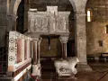 Interno del duomo di Barga con un leone in marmo e un pulpito scolpito.