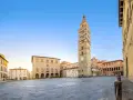 Piazza del Duomo con la maestosa cattedrale di San Zeno e il suo campanile svettante, sotto un cielo azzurro.