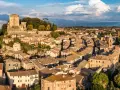 Sarteano cosa vedere: vista aerea del borgo medievale con il castello in cima alla collina e le case con i tetti in cotto.