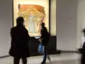 Un'opera d'arte a Monterchi, cosa vedere: visitatori ammirano un affresco con figure sacre in un museo.