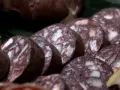 Fette di biroldo toscano, un salume scuro con striature bianche, pronto per essere gustato.