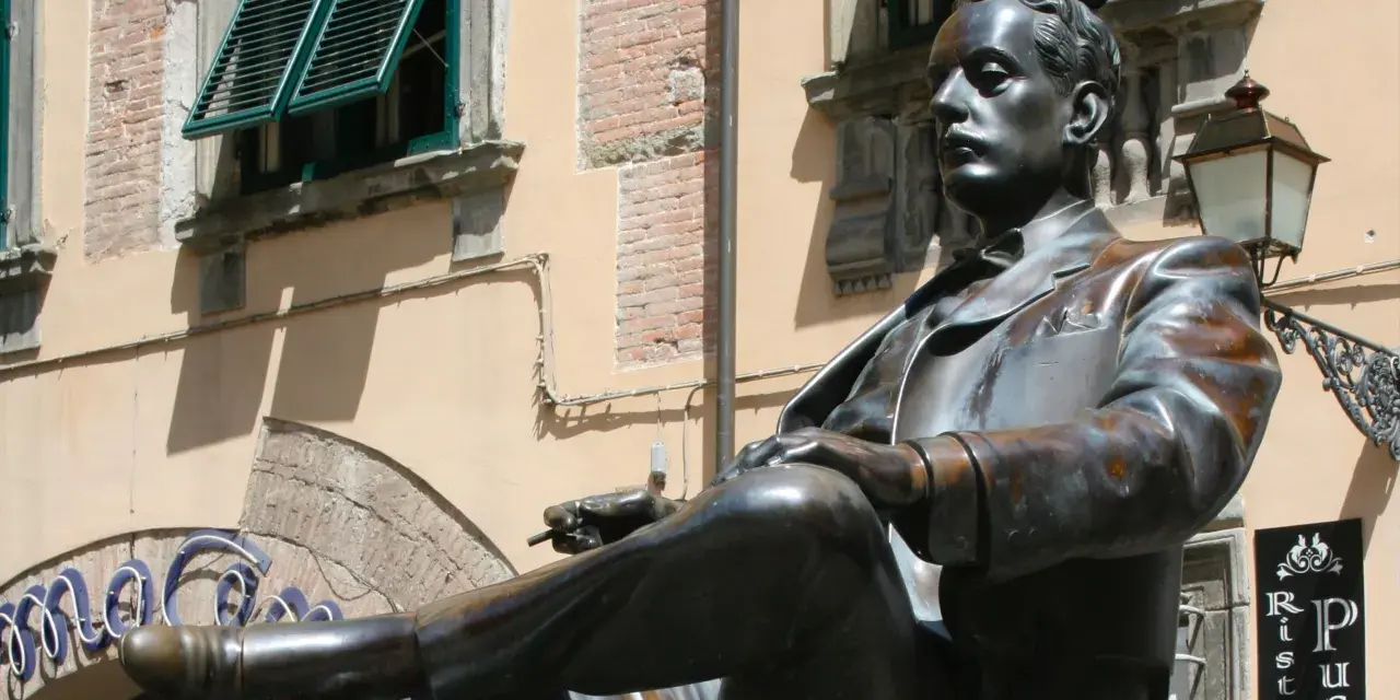 Statua di bronzo in piazza San Michele a Lucca, un uomo elegante con sigaretta.