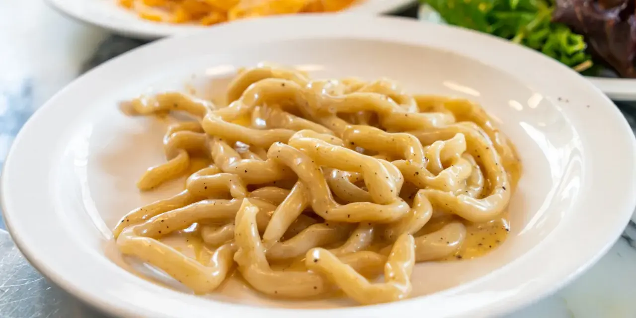 Pici cacio e pepe, un classico da provare a Siena. Pasta fresca condita con formaggio e pepe nero.