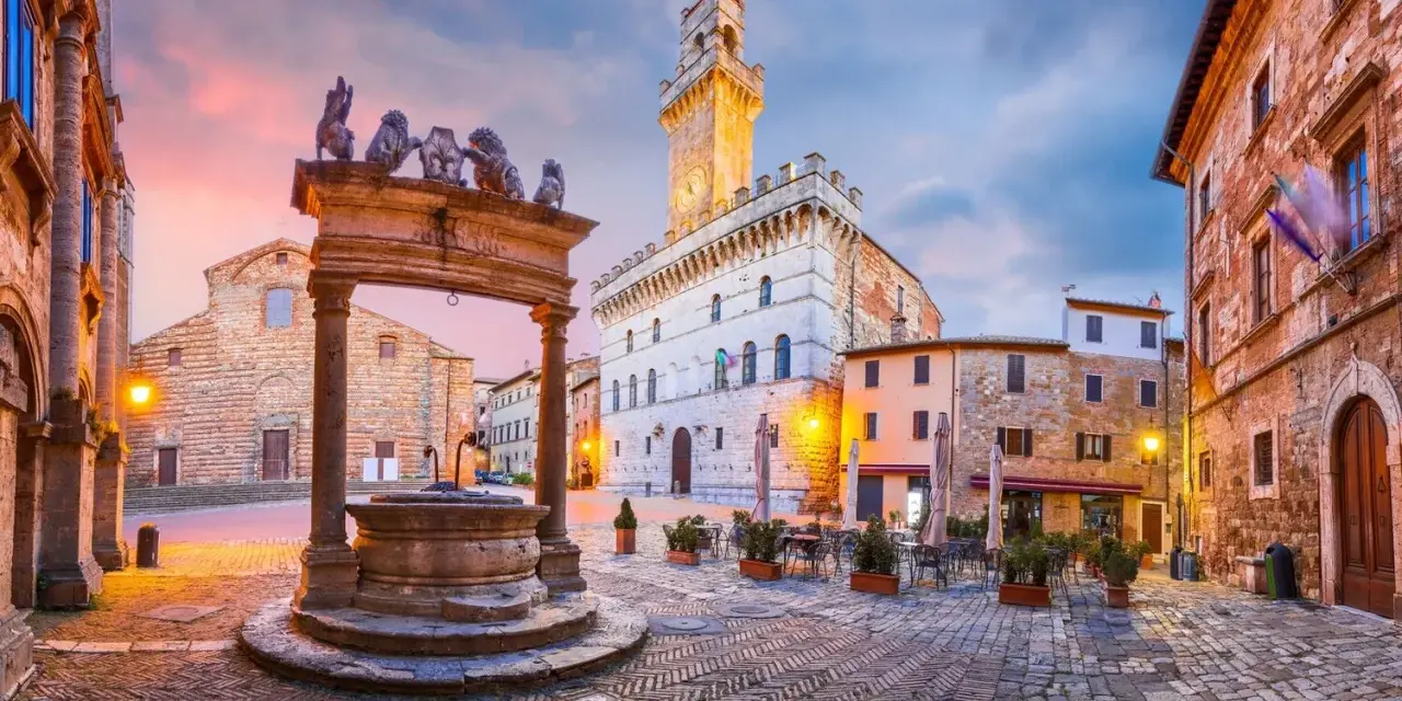 Piazza del Popolo, cuore del centro storico di Arezzo, con la sua fontana rinascimentale e il Palazzo Comunale illuminato al tramonto.