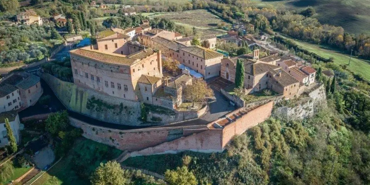Borgo medievale di S. Giovanni d'Asso, con il suo imponente castello e le case in pietra, domina le dolci colline toscane.