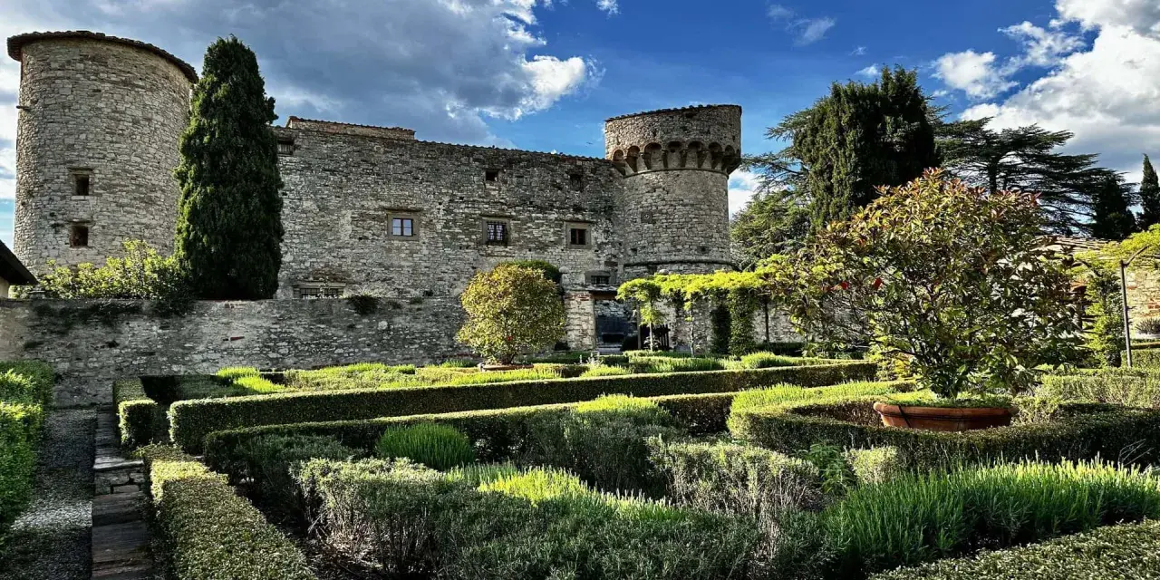 Giardini curati e torri antiche del castello di Meleto, un luogo ideale per visite indimenticabili.