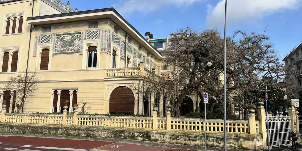 Villa Argentina a Viareggio, con la sua facciata decorata e un grande albero spoglio.