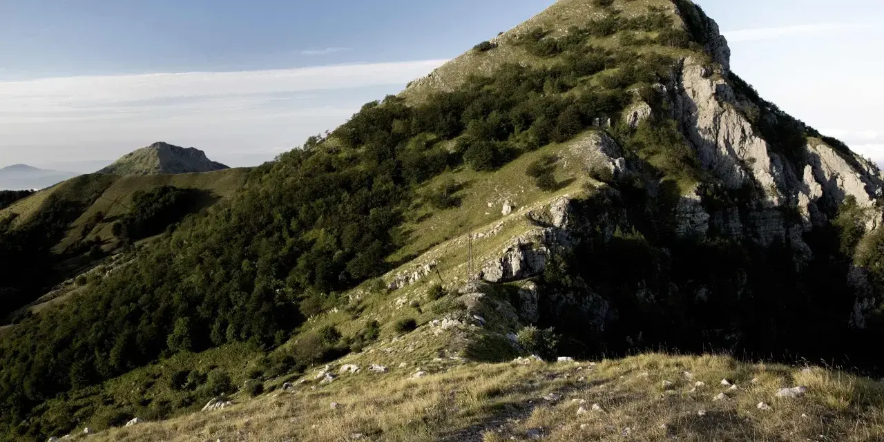 Panoramica del monte Matanna con pendii erbosi, rocce affioranti e boschi di faggi.