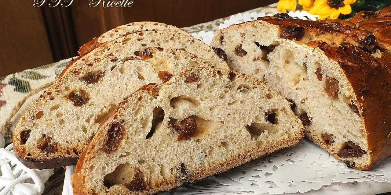 Fette di buccellato lucchese, un dolce tradizionale con uvetta e canditi, su un piatto decorato.