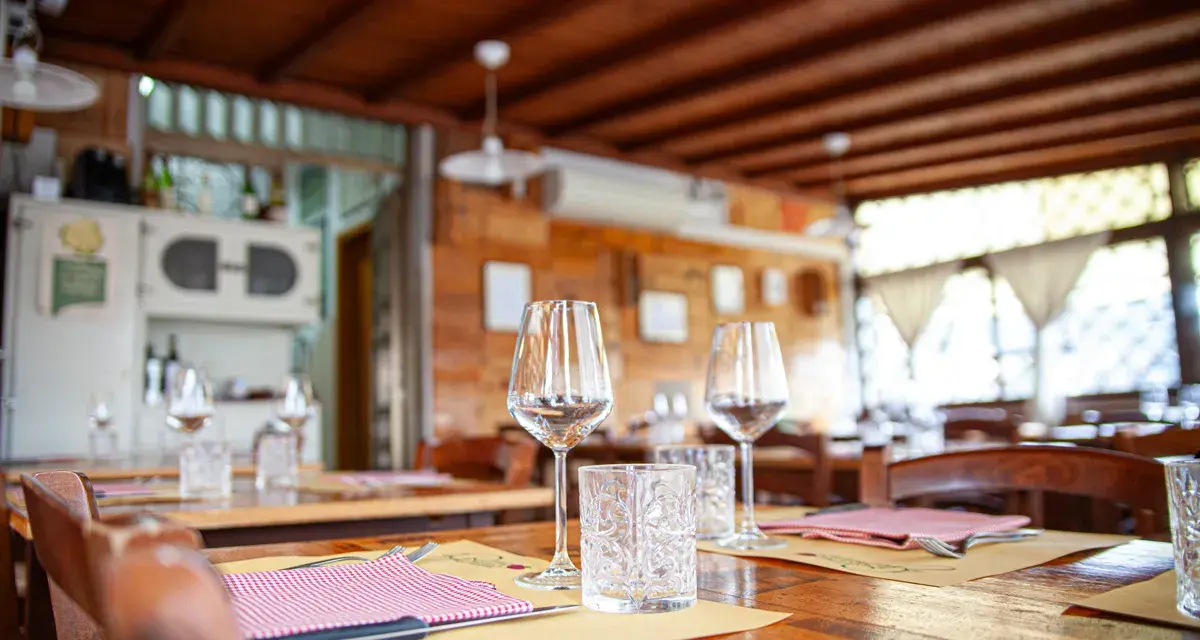Tavoli apparecchiati in un'osteria ad Arezzo e dintorni, pronti per accogliere i commensali.