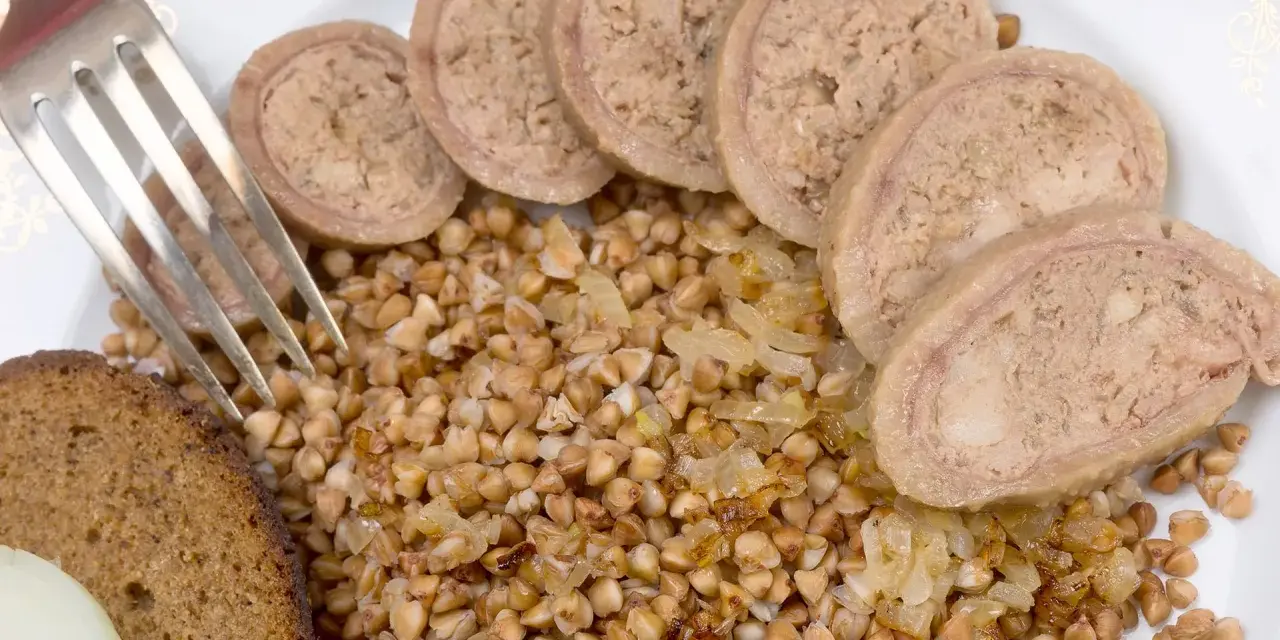 Piatto con grano saraceno, pane nero, cipolle e fette di collo ripieno.