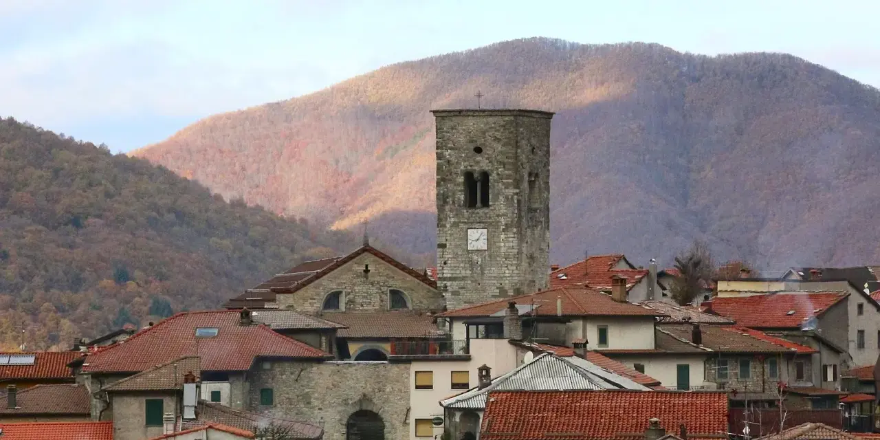 Torre medievale e tetti rossi a Careggine, un borgo incantevole da scoprire tra le montagne autunnali.