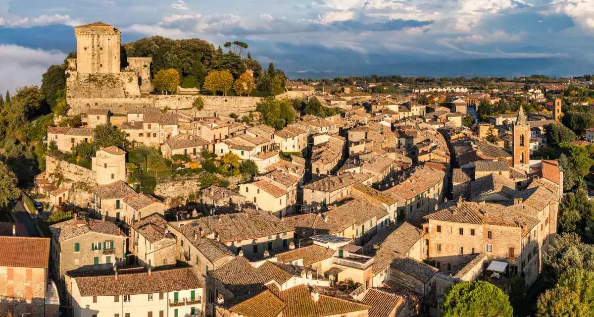 Sarteano cosa vedere: vista aerea del borgo medievale con il castello in cima alla collina e le case con i tetti in cotto.
