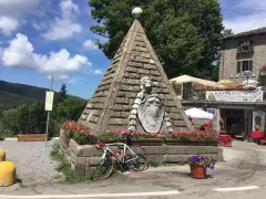 Le piramidi di Abetone, con una bici da corsa appoggiata, circondate da fiori e un ristorante.