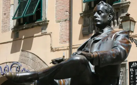 Statua di bronzo in piazza San Michele a Lucca, un uomo elegante con sigaretta.