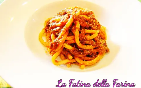 Pici alla nana, un piatto di pasta fatta in casa condita con un ricco ragù, servito su un piatto bianco.