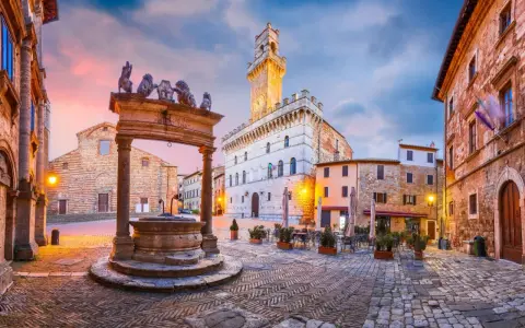 Piazza del Popolo, cuore del centro storico di Arezzo, con la sua fontana rinascimentale e il Palazzo Comunale illuminato al tramonto.