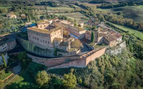Borgo medievale di S. Giovanni d'Asso, con il suo imponente castello e le case in pietra, domina le dolci colline toscane.