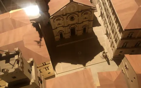 Modello in legno del duomo di Pienza e del suo complesso, con un'ombra a forma di croce che si proietta sulla piazza.