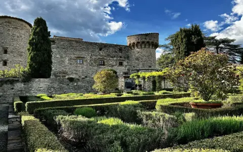 Giardini curati e torri antiche del castello di Meleto, un luogo ideale per visite indimenticabili.
