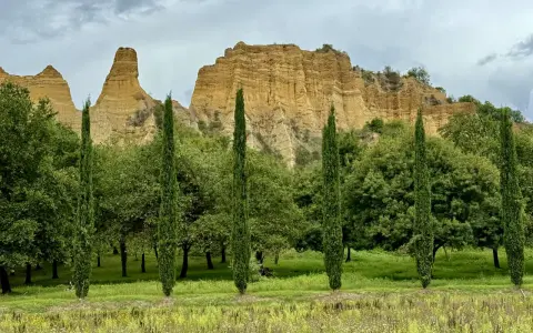 Paesaggio con calanchi ocra e cipressi slanciati, un invito a percorrere il sentiero dell'acqua zolfina.