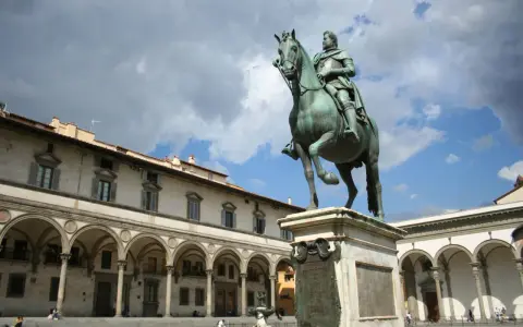 Statua equestre nella piazza della Santissima Annunziata, Firenze. Edifici storici con portici sullo sfondo.