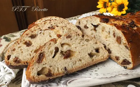 Fette di buccellato lucchese, un dolce tradizionale con uvetta e canditi, su un piatto decorato.