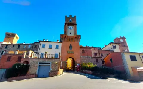 Torre dell'orologio a Marciano Italia, con un arco medievale e case in pietra.