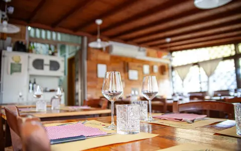 Tavoli apparecchiati in un'osteria ad Arezzo e dintorni, pronti per accogliere i commensali.