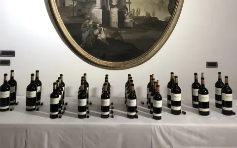 Bottiglie di vino Oreno della Tenuta Setteponti disposte su un tavolo, con un dipinto ovale sullo sfondo.