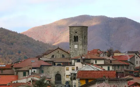 Torre medievale e tetti rossi a Careggine, un borgo incantevole da scoprire tra le montagne autunnali.