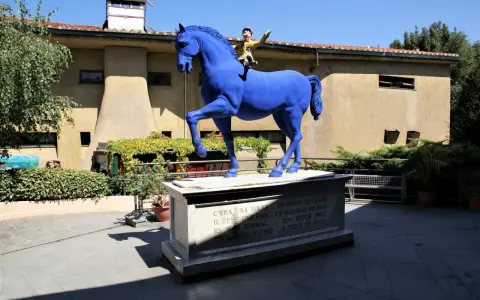 Un cavallo blu con Pinocchio a cavalcioni, simbolo del paese di Collodi. La statua è posta su un piedistallo con la frase "C'era una volta... un pezzo di legno" in più lingue.