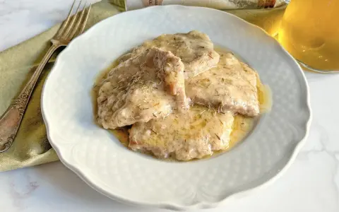 Grifi in umido, teneri e succulenti, serviti su un piatto bianco con forchetta e bicchiere di vino.