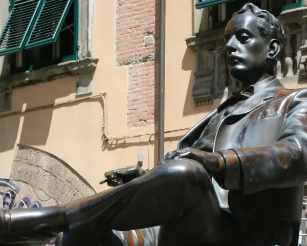 Statua di bronzo in piazza San Michele a Lucca, un uomo elegante con sigaretta.